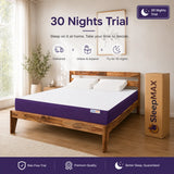 A bed with a purple and white SleepMAX mattress set in a bright bedroom, alongside a tall cardboard box labeled SleepMAX and promotional text reading '30 Nights Trial'.